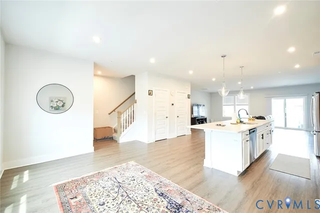 a large kitchen with a wooden floor and a view of living room