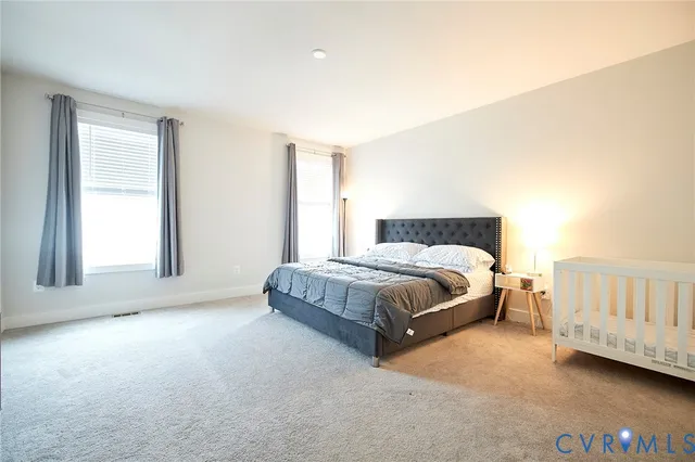 a spacious bedroom with a bed and a window