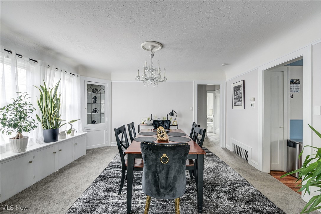 2852 Ludlow Road Cleveland, OH 44120 - Photo 14 of 50 Carpeted dining area with a notable chandelier and a textured ceiling