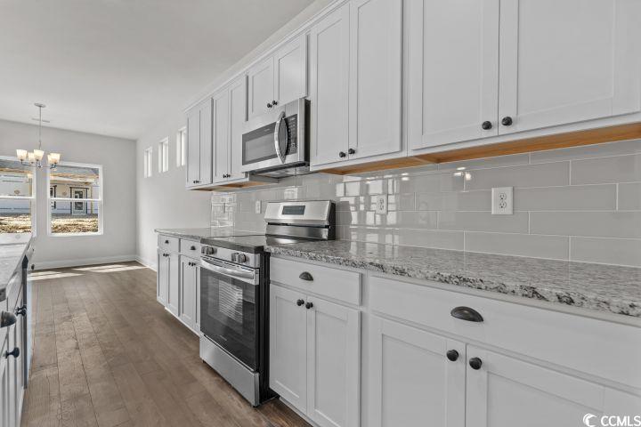 112 Furnies Place Conway, SC 29526 - Photo 12 of 24 Kitchen featuring stainless steel appliances, white cabinetry, dark wood finished floors, decorative light fixtures, and light stone counters