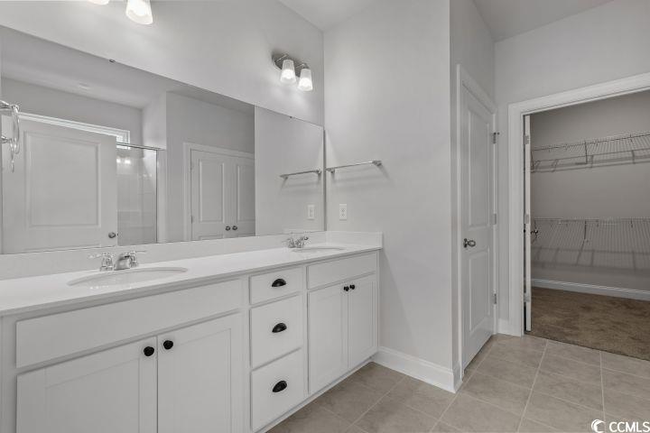 112 Furnies Place Conway, SC 29526 - Photo 16 of 24 Bathroom featuring double vanity, light tile patterned flooring, a walk in closet, and an enclosed shower