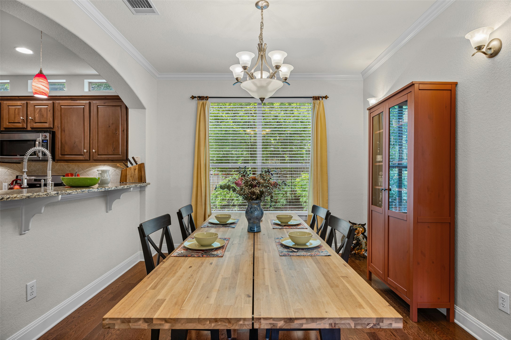 6708 Menchaca Road, Unit 10 Austin, TX 78745 - Photo 10 of 30 A well-lit dining area featuring a generous window overlooking lush greenery and an adjacent kitchen passthrough.