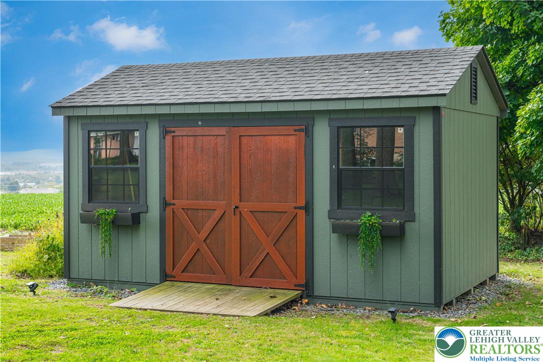 2569 Woods Edge Road Bath, PA 18014 - Photo 31 of 40 A spacious backyard storage shed features classic double doors and integrated window flower boxes.