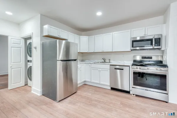 a kitchen with stainless steel appliances a refrigerator stove and microwave