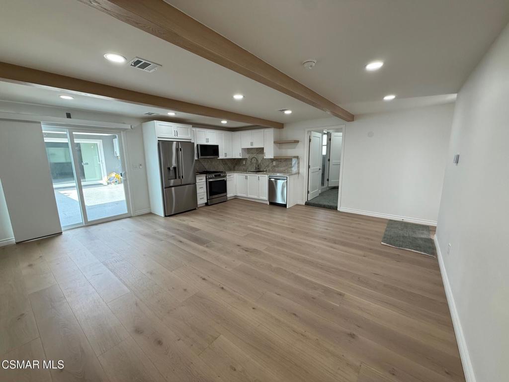 102 West Alta Green Port Hueneme, CA 93041 - Photo 15 of 23 an empty room with wooden floor and kitchen view