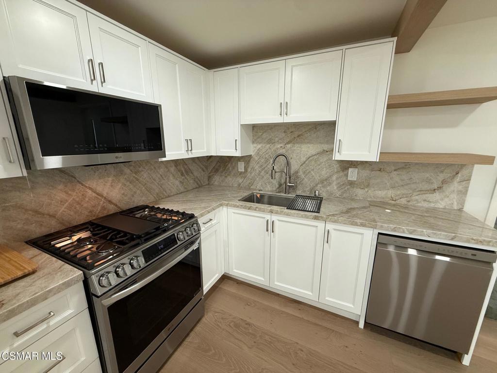 102 West Alta Green Port Hueneme, CA 93041 - Photo 16 of 23 a kitchen with granite countertop a sink stove and microwave