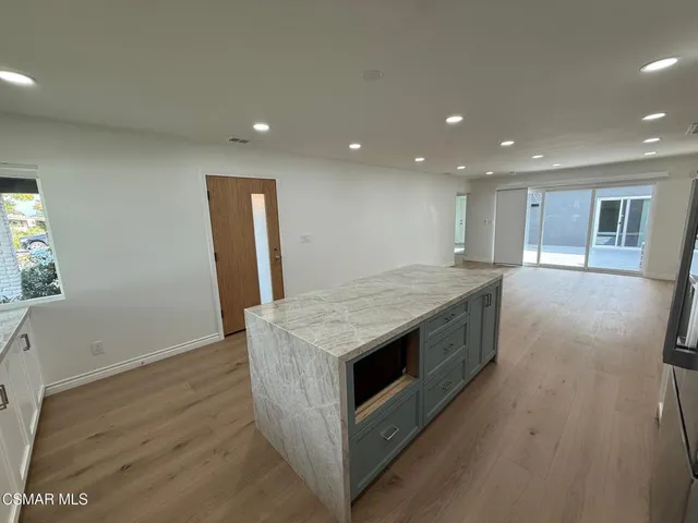 a kitchen with a stove and a wooden floor