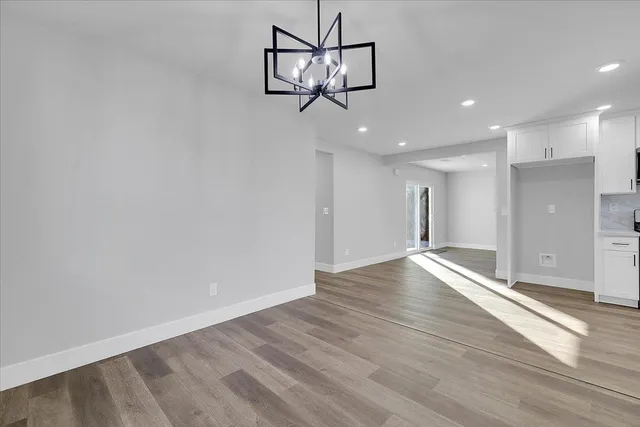 a view of empty room with wooden floor and window