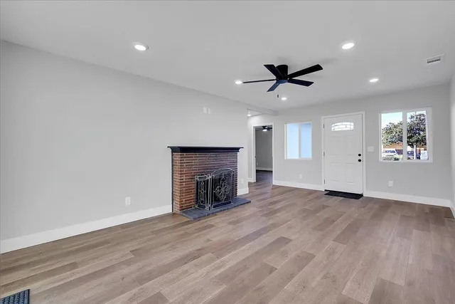 an empty room with fan and windows