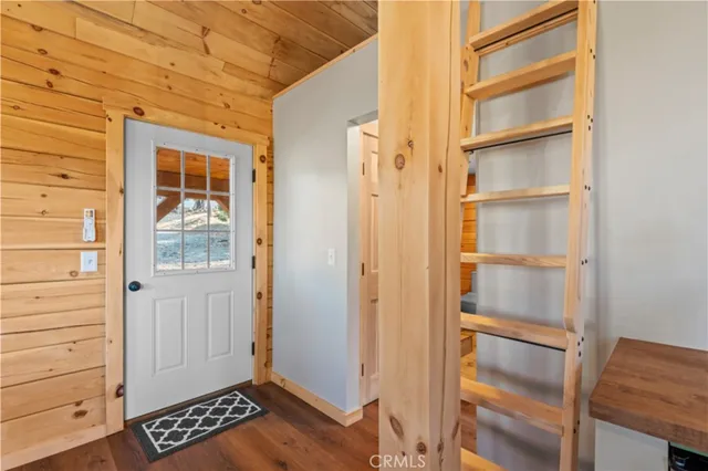 a view of an empty room with cabinet and wooden floor