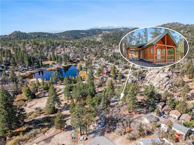 an aerial view of a house with a yard and mountain view in back