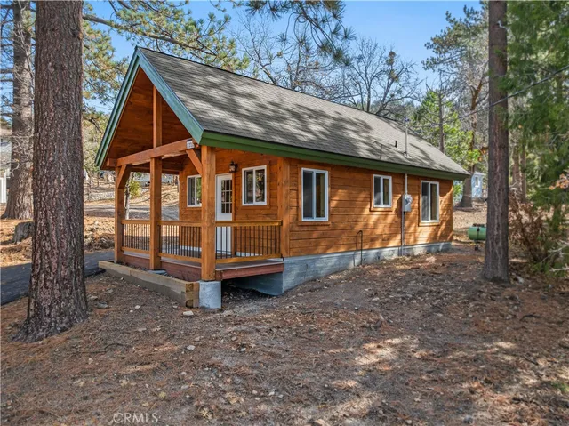 a view of backyard with a deck and large trees