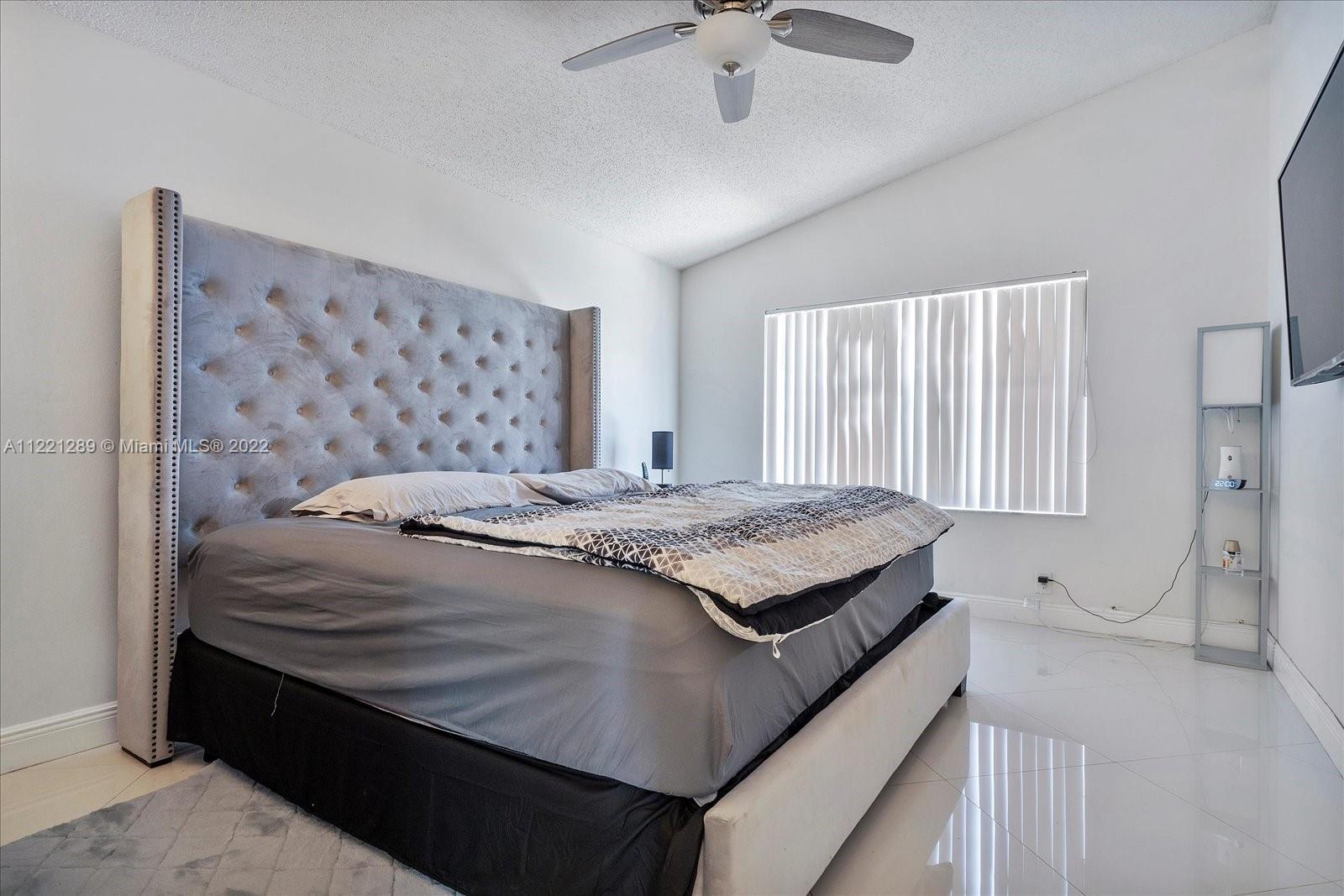 7384 Granada Way Margate, FL 33063 - Photo 19 of 30 a bedroom with a bed and a chandelier