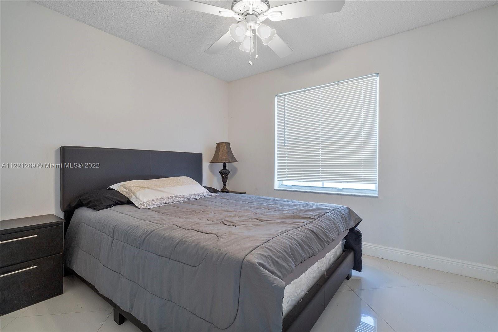 7384 Granada Way Margate, FL 33063 - Photo 22 of 30 a bedroom with a bed and window