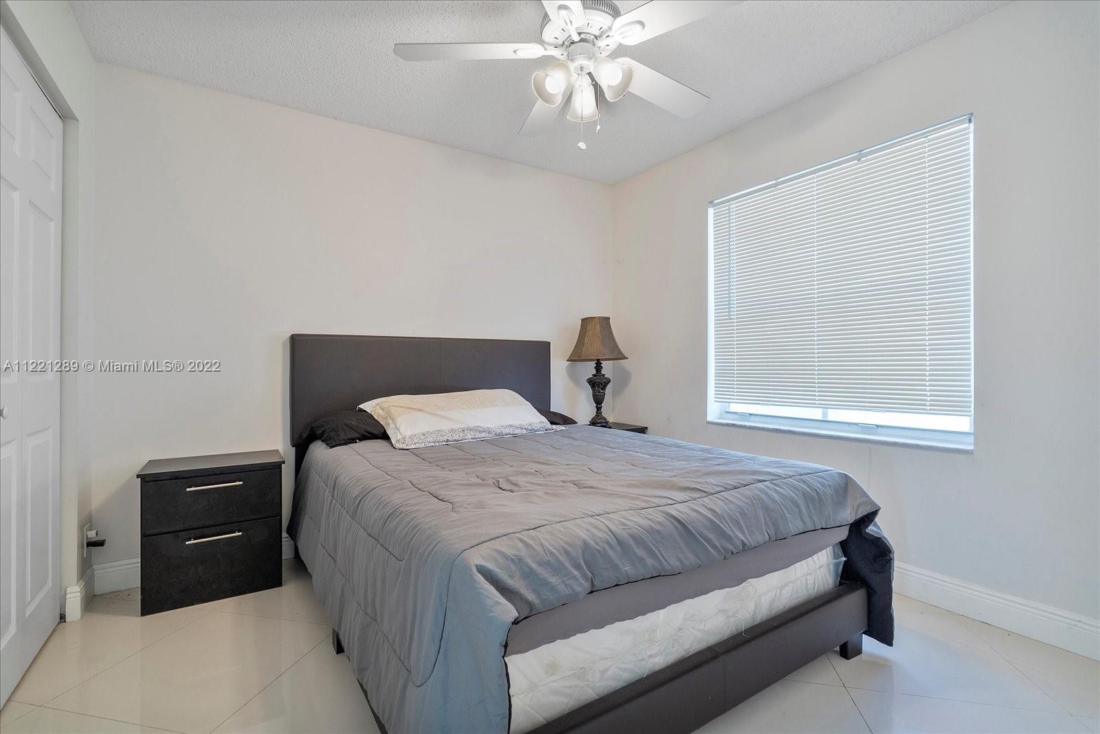 7384 Granada Way Margate, FL 33063 - Photo 23 of 30 a bedroom with a bed and a chandelier