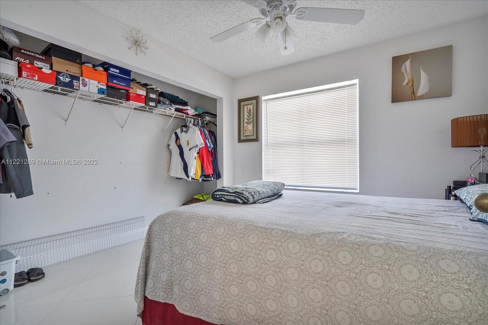 7384 Granada Way Margate, FL 33063 - Photo 25 of 30 a bedroom with a bed and a walk in closet