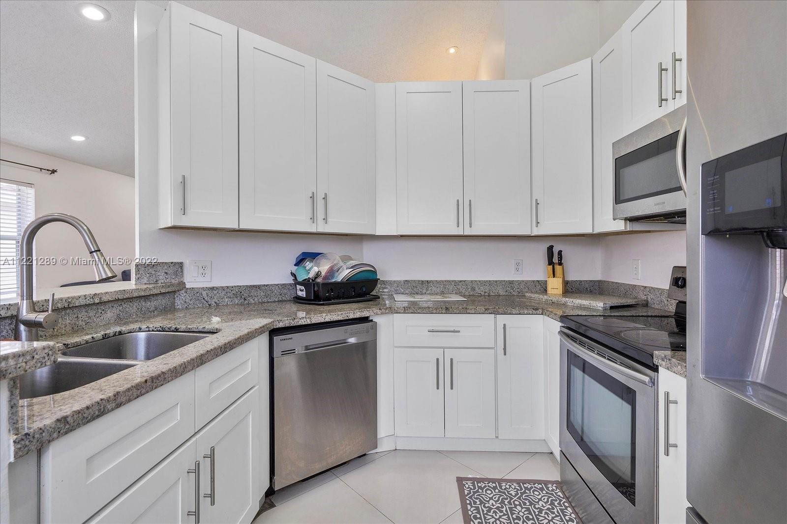 7384 Granada Way Margate, FL 33063 - Photo 5 of 30 a kitchen with stainless steel appliances granite countertop a sink stove and cabinets