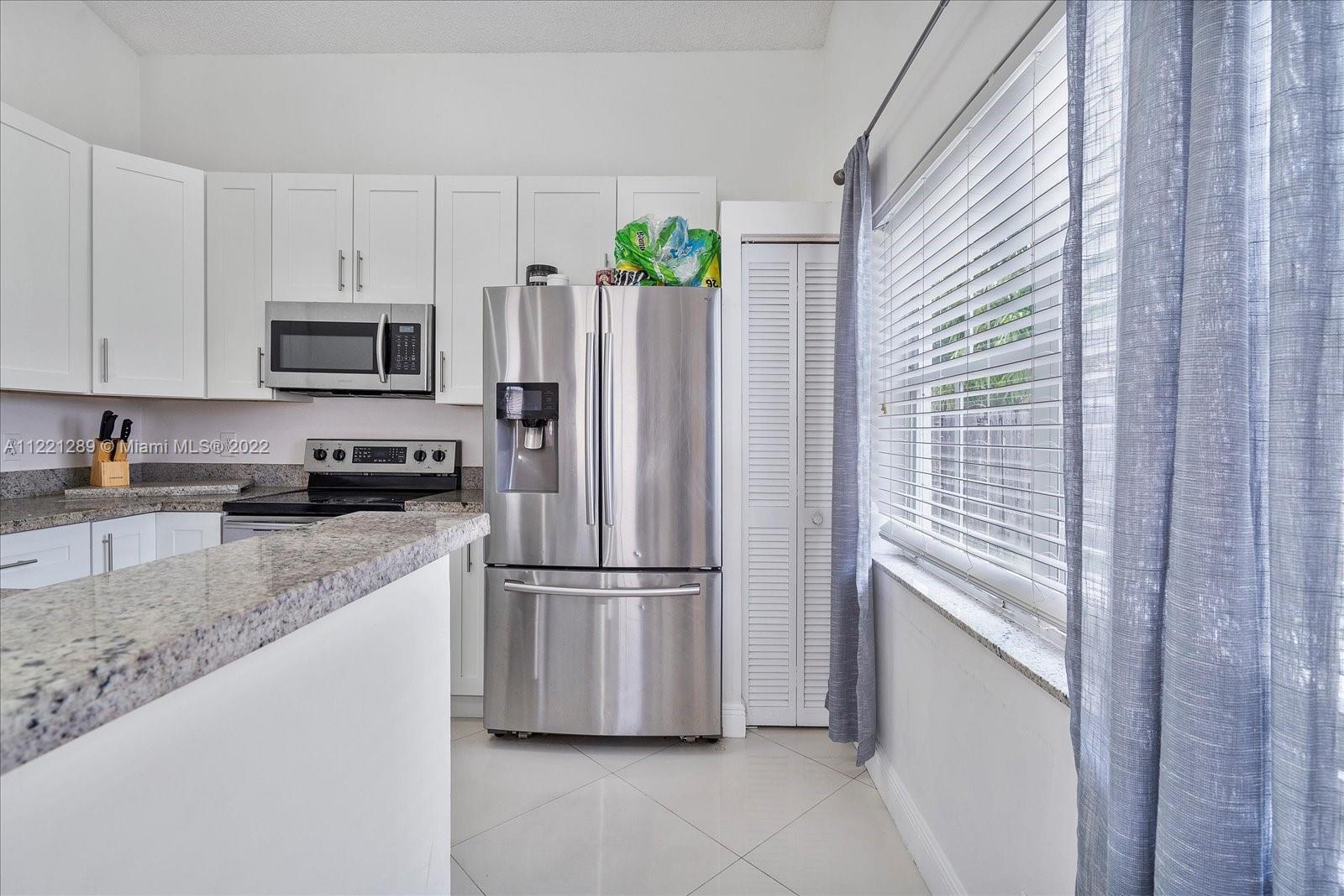 7384 Granada Way Margate, FL 33063 - Photo 6 of 30 a kitchen with appliances a refrigerator and a stove top oven