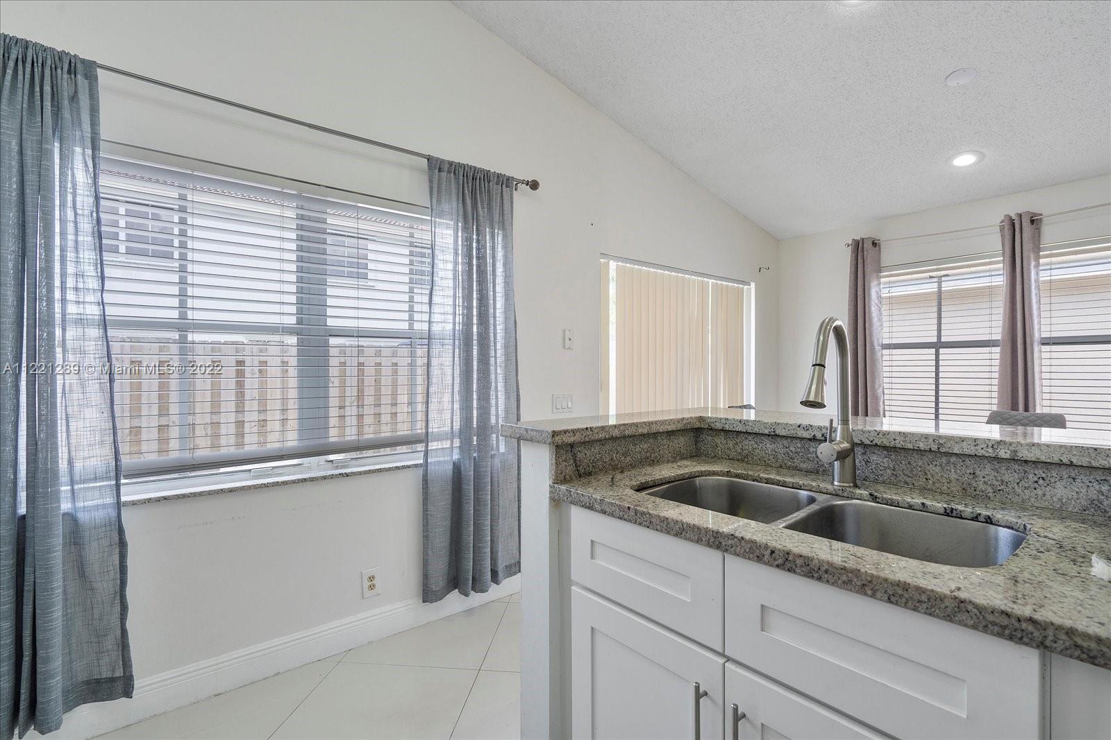 7384 Granada Way Margate, FL 33063 - Photo 8 of 30 a kitchen with granite countertop a sink and cabinets