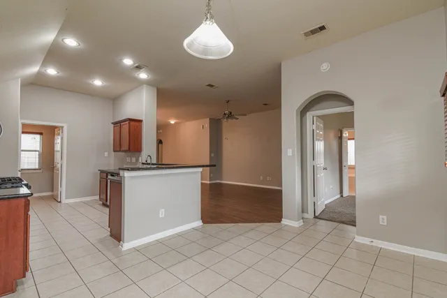 a view of a kitchen with kitchen island granite countertop a refrigerator and a sink