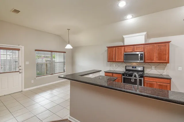 a kitchen with stainless steel appliances granite countertop a sink stove and microwave