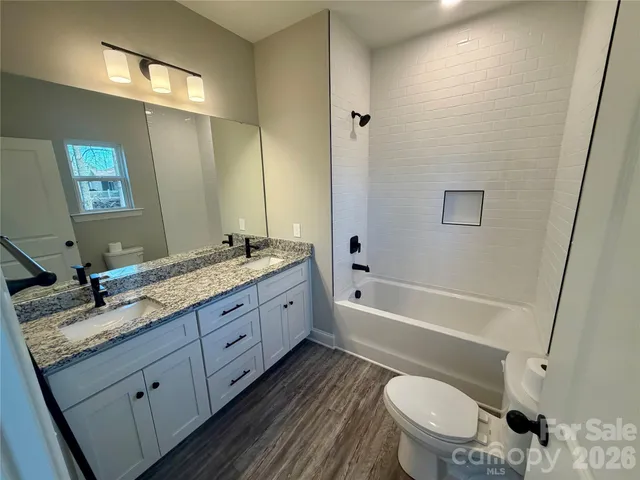 a bathroom with a granite countertop toilet a sink and bathtub