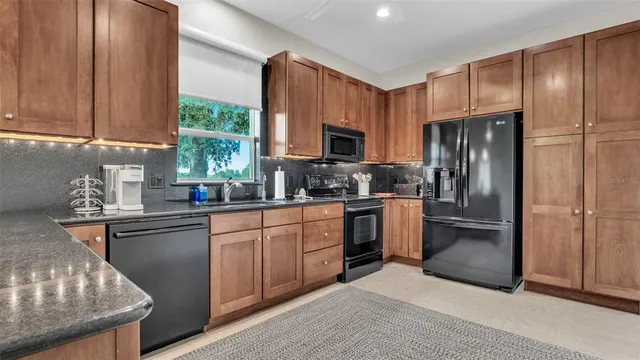 a kitchen with stainless steel appliances granite countertop wooden cabinets stove top oven and sink