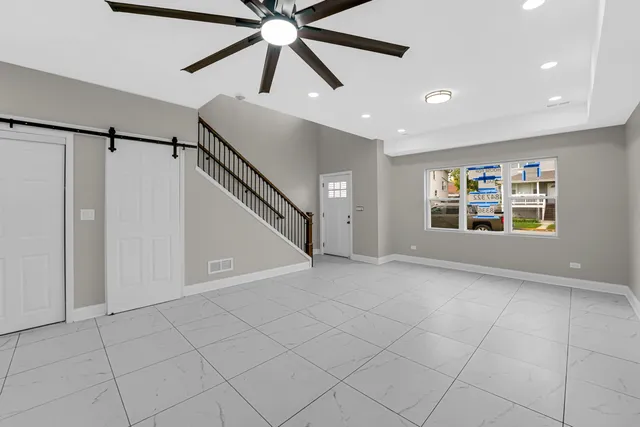 a view of an empty room with a window and a ceiling fan