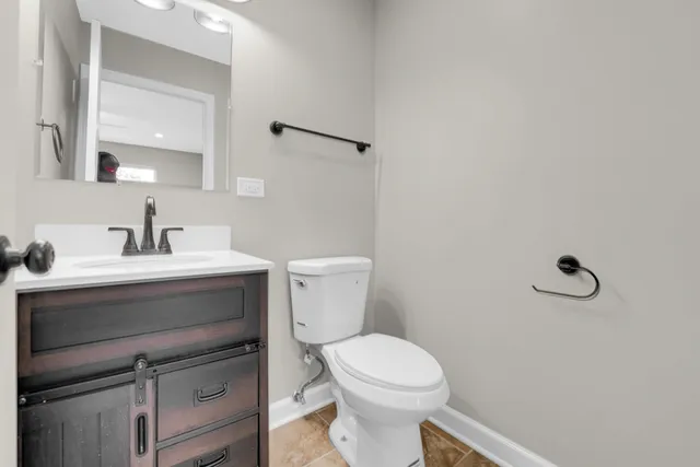 a bathroom with a sink mirror vanity and toilet