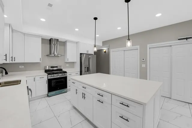 a kitchen with white cabinets and stainless steel appliances