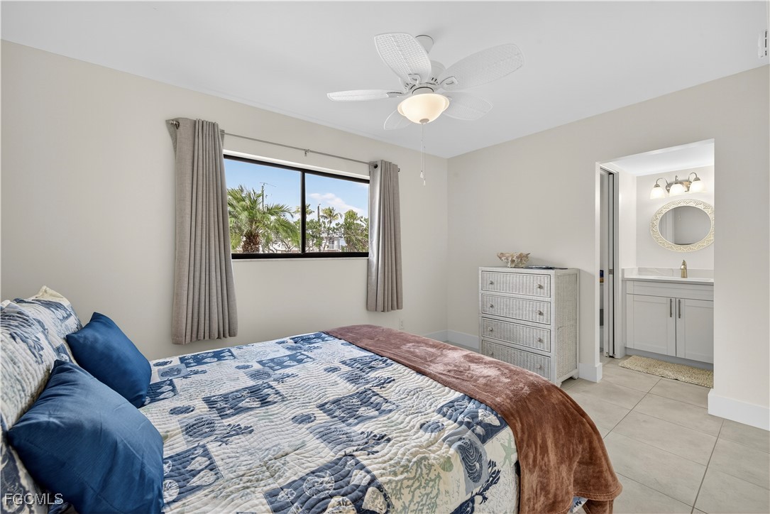 200 Lenell Road, Unit 214 Fort Myers Beach, FL 33931 - Photo 16 of 32 a bedroom with a bed and a chandelier