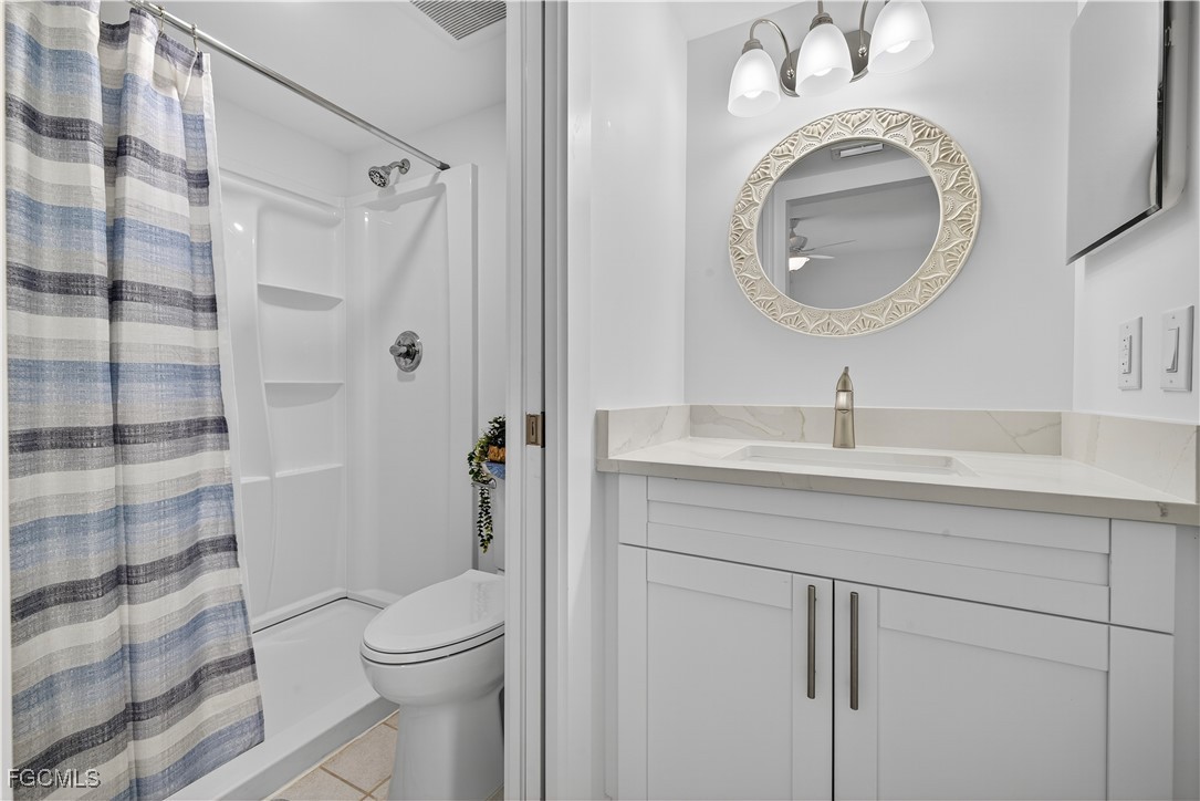 200 Lenell Road, Unit 214 Fort Myers Beach, FL 33931 - Photo 18 of 32 a bathroom with a sink a toilet and a mirror