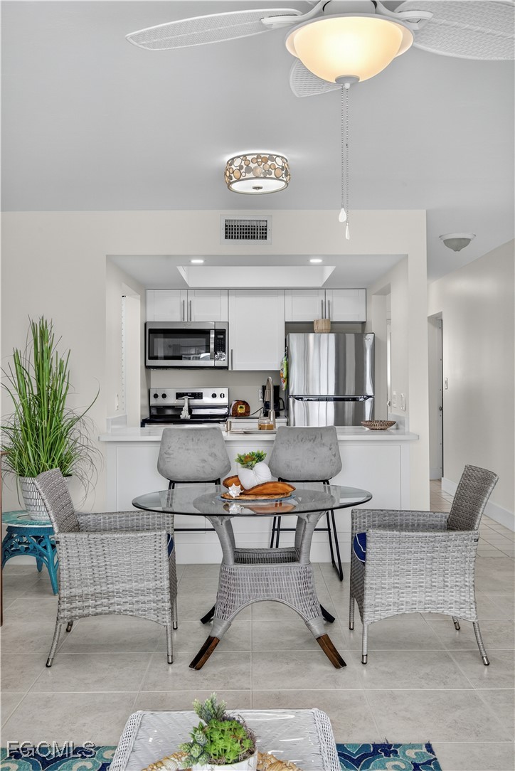 200 Lenell Road, Unit 214 Fort Myers Beach, FL 33931 - Photo 23 of 32 a kitchen with stainless steel appliances kitchen island granite countertop a table chairs sink and cabinets