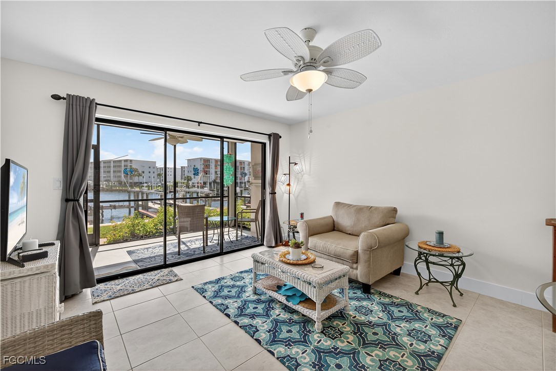 200 Lenell Road, Unit 214 Fort Myers Beach, FL 33931 - Photo 5 of 32 a living room with furniture and a floor to ceiling window