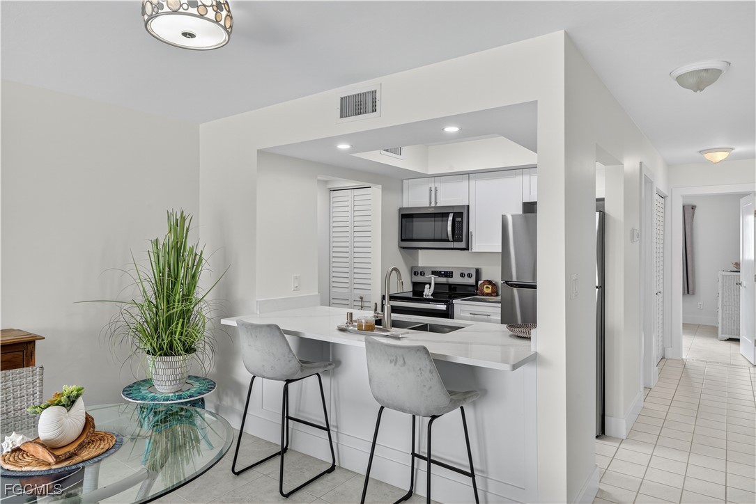 200 Lenell Road, Unit 214 Fort Myers Beach, FL 33931 - Photo 10 of 32 a kitchen with a table and chairs in it
