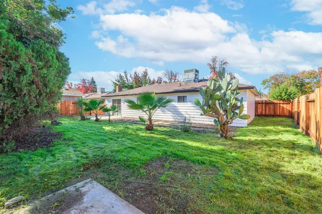 a green field with lots of trees in the background