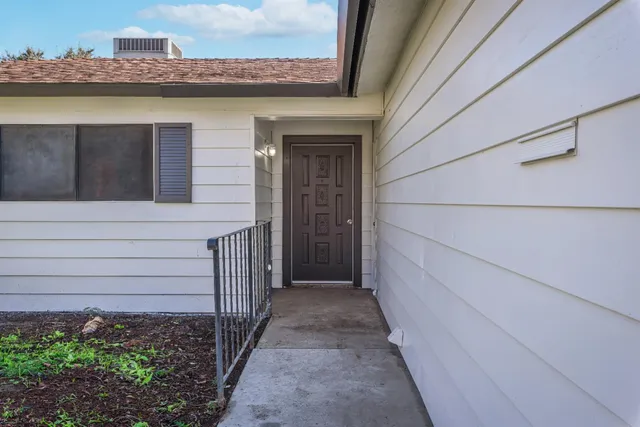 a view of a pathway of a house with a small yard and wooden floor
