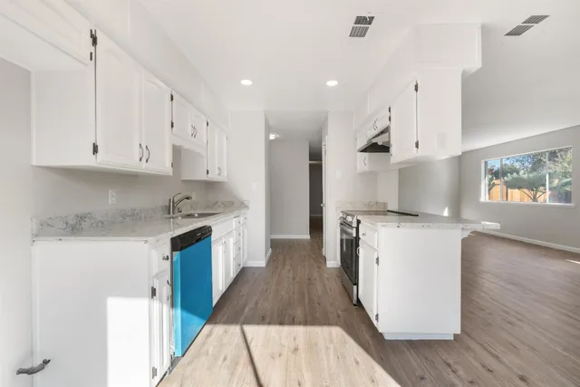 a kitchen with stainless steel appliances granite countertop a stove a sink and a refrigerator