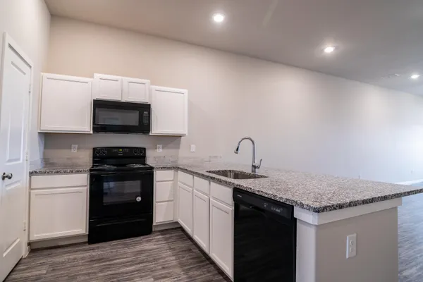 a kitchen with stainless steel appliances granite countertop a sink and a stove