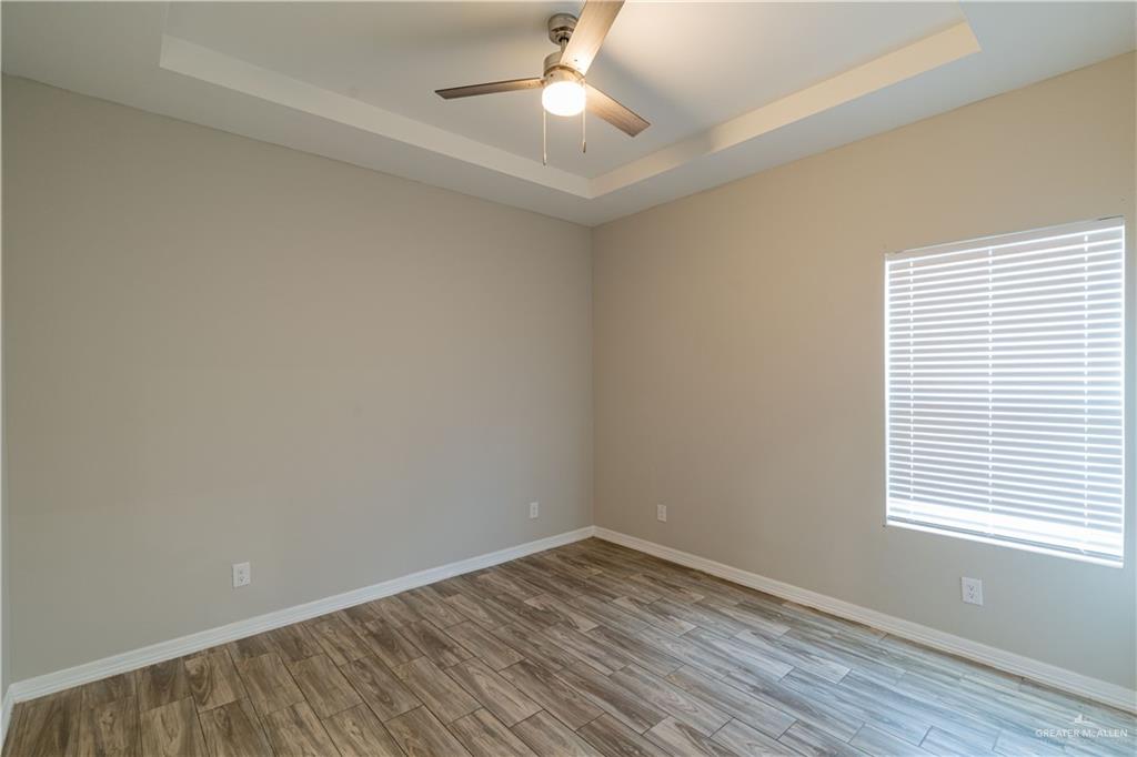 1005 West Kohala Avenue, Unit 4 Alton, TX 78573 - Photo 14 of 21 wooden floor in an empty room with a window