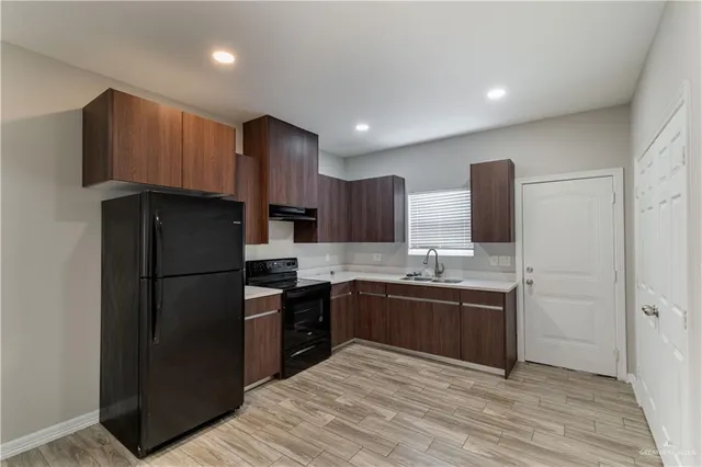 a kitchen with stainless steel appliances granite countertop a refrigerator and a sink
