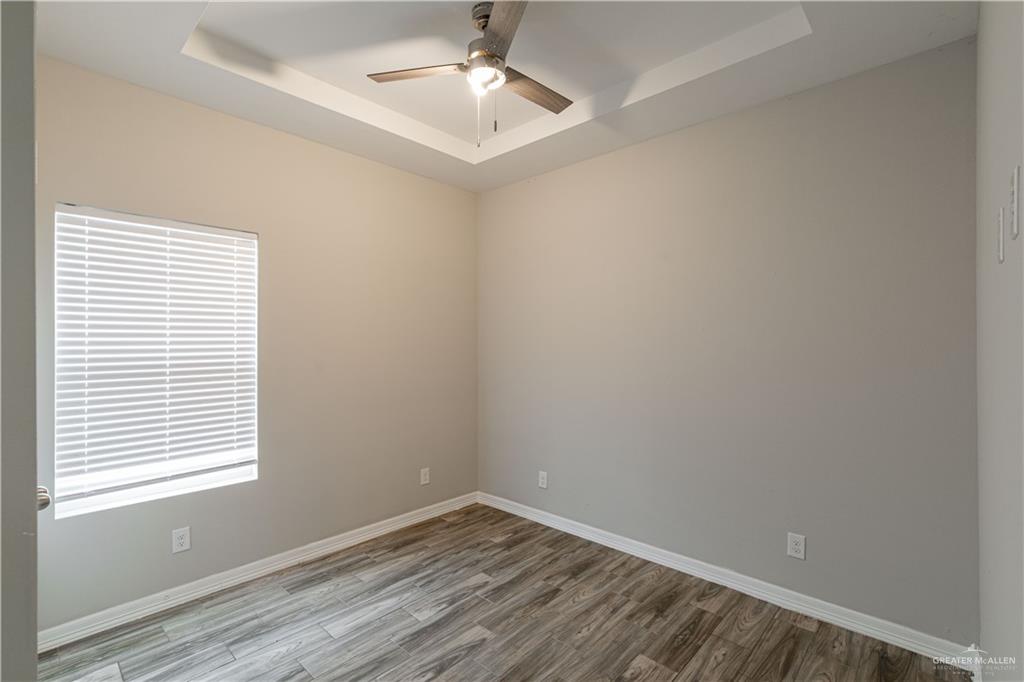 1005 West Kohala Avenue, Unit 4 Alton, TX 78573 - Photo 10 of 21 an empty room with wooden floor and windows