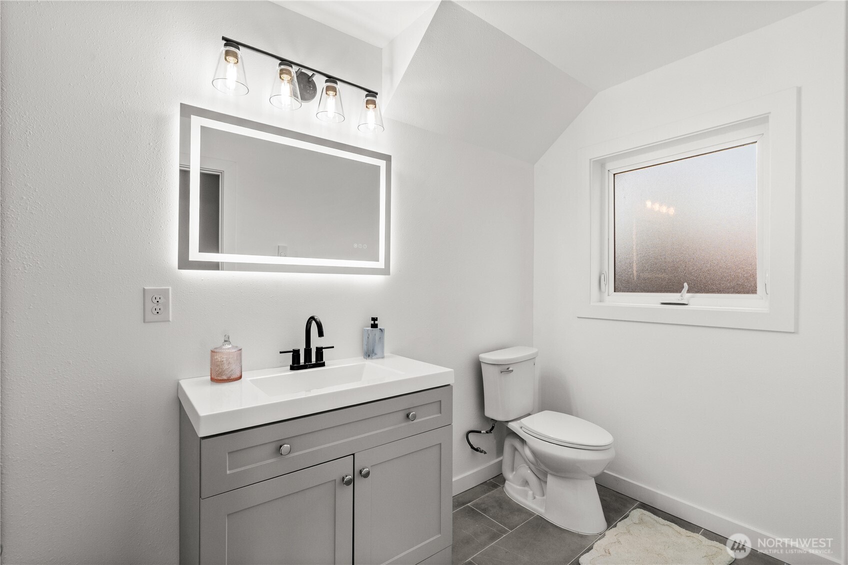 4706 Southwest Eddy Street Seattle, WA 98136 - Photo 14 of 27 a bathroom with a toilet sink and mirror