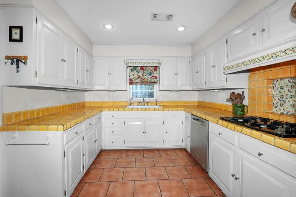 a kitchen with a sink window and cabinets