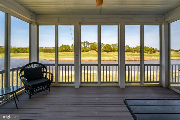 a living room with furniture floor to ceiling window and wooden floor