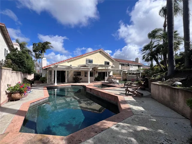 a view of a house with swimming pool and sitting area