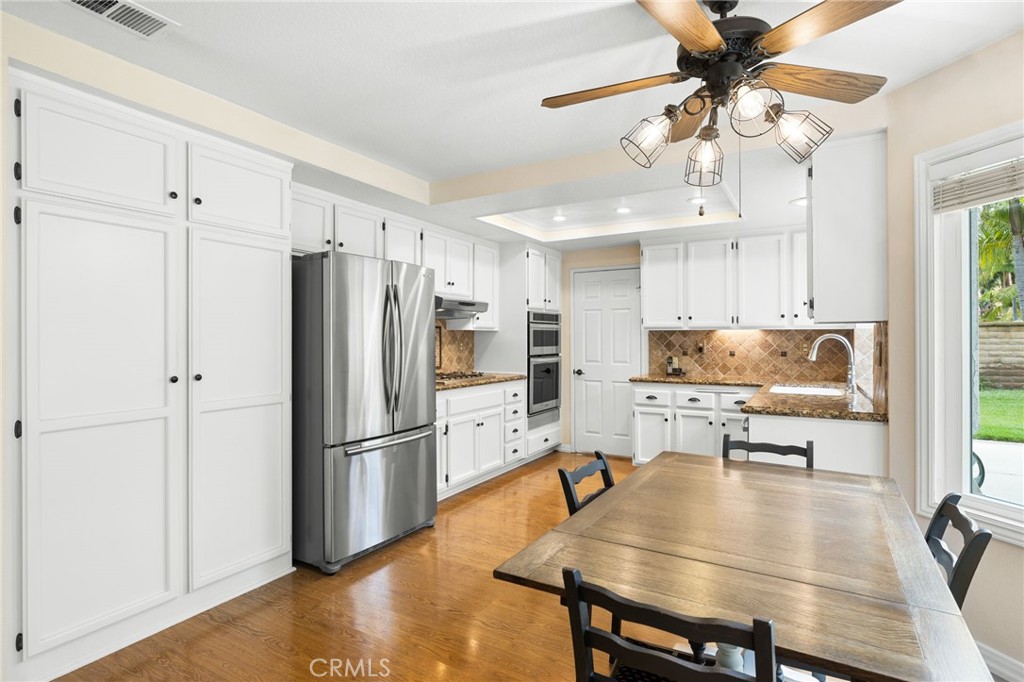 855 Ave Bernardo San Dimas, CA 91773 - Photo 18 of 65 a kitchen with stainless steel appliances a dining table chairs refrigerator and cabinets