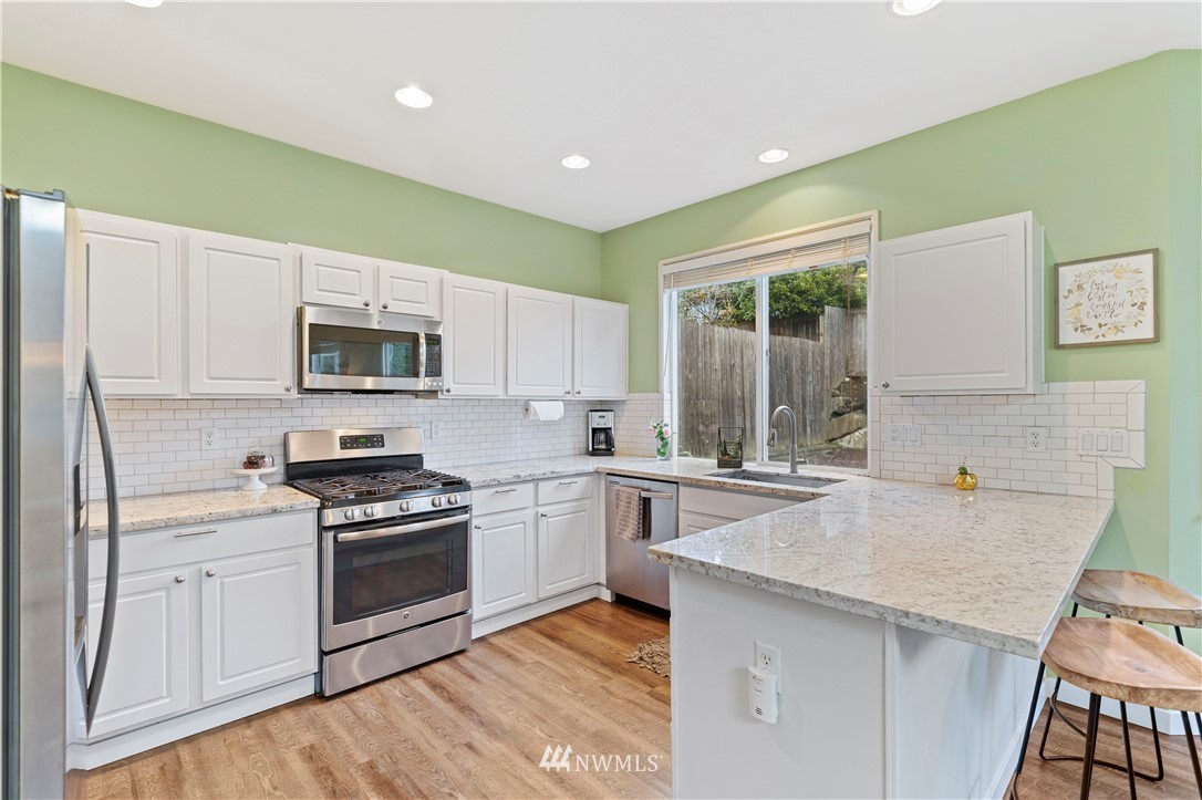 5042 Northeast 4th Place Renton, WA 98059 - Photo 9 of 29 a kitchen with a sink stove top oven and cabinets