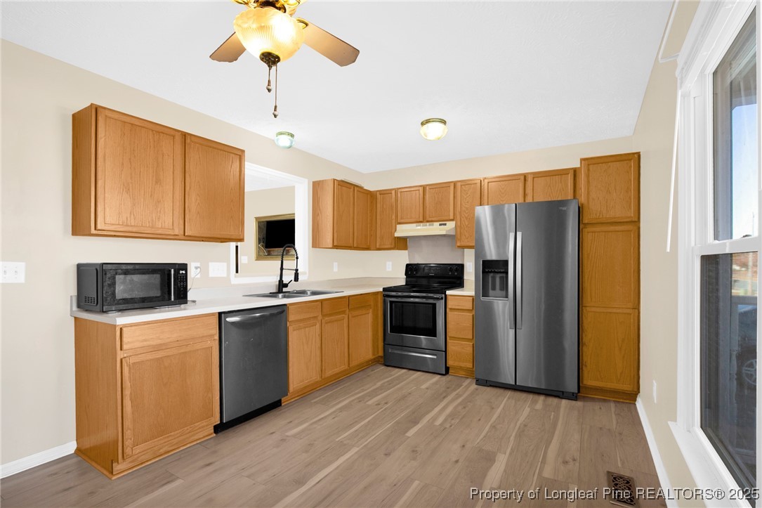 101 2 Hours Court Raeford, NC 28376 - Photo 10 of 30 a kitchen with stainless steel appliances granite countertop a refrigerator a stove top oven a sink dishwasher and a refrigerator with wooden floor