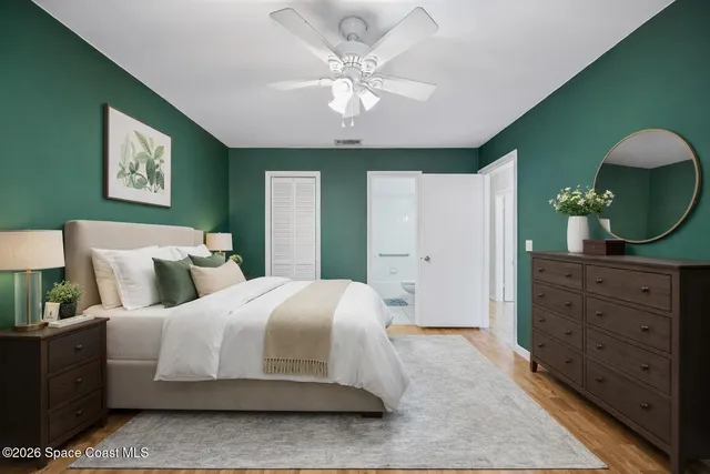 a view of a white house with a big yard and potted plants